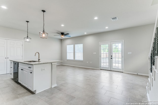 kitchen featuring french doors, white cabinets, sink, an island with sink, and ceiling fan