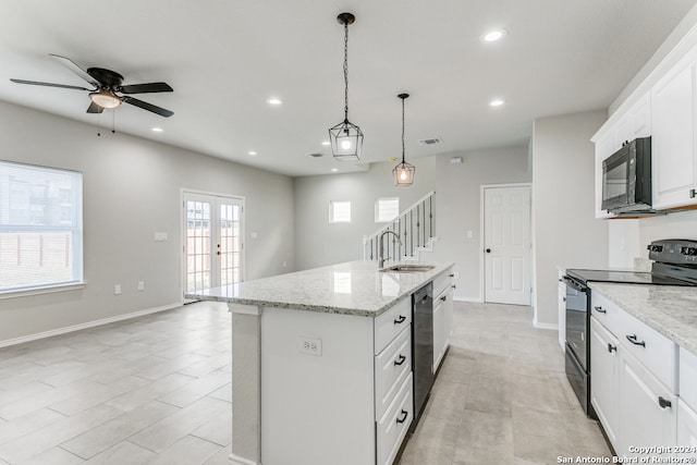 kitchen featuring black appliances, sink, hanging light fixtures, an island with sink, and white cabinetry