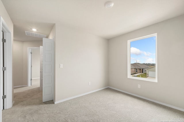 spare room featuring light carpet