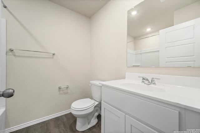 bathroom with toilet, a shower, vanity, and wood-type flooring