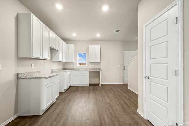 kitchen featuring white cabinetry, sink, light stone counters, and dark hardwood / wood-style flooring