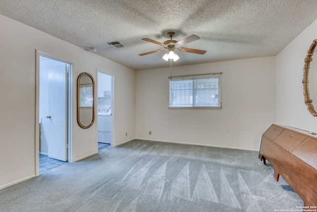 unfurnished room with ceiling fan, a textured ceiling, light carpet, and washer / clothes dryer