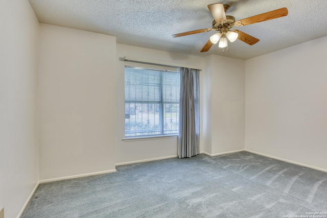 carpeted spare room featuring ceiling fan and a textured ceiling