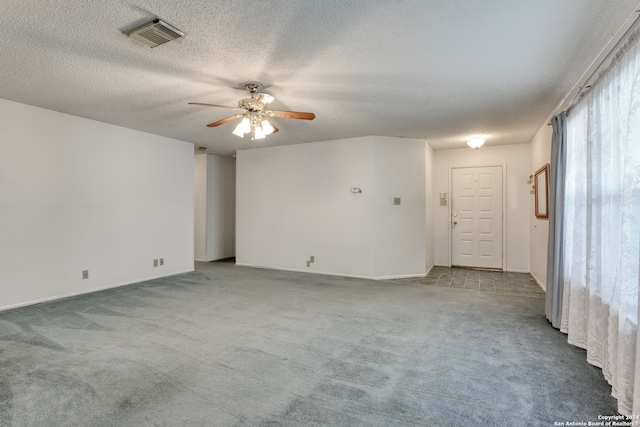 spare room with light carpet, a textured ceiling, and ceiling fan