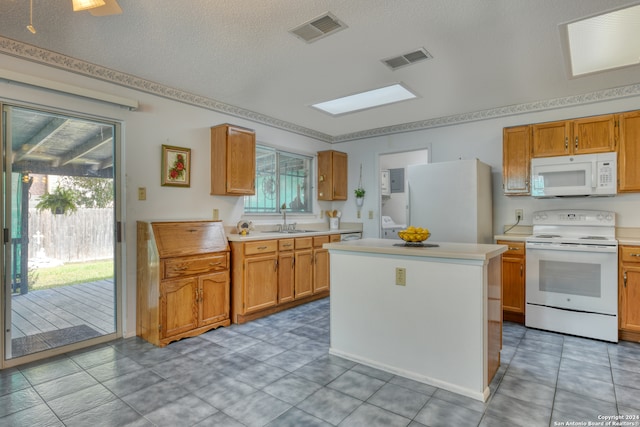 kitchen featuring a center island, white appliances, sink, and plenty of natural light