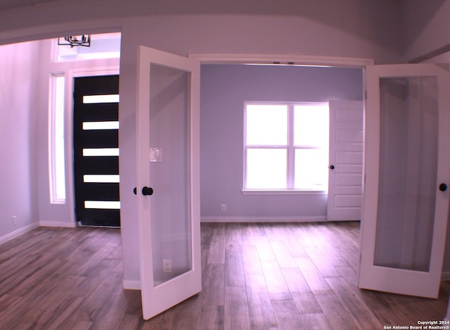 foyer with hardwood / wood-style floors, an inviting chandelier, and french doors