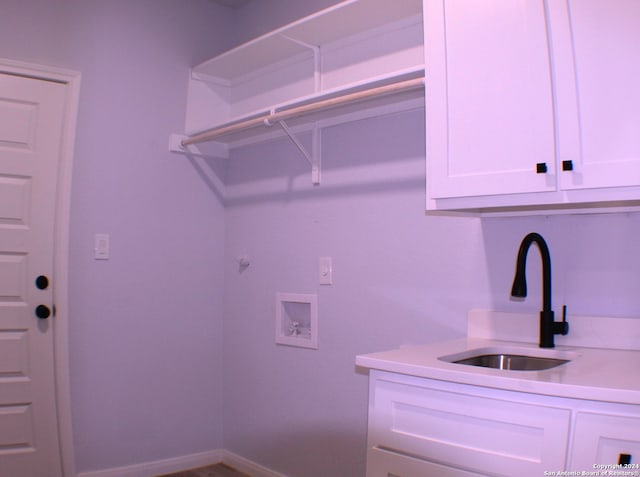 clothes washing area featuring cabinets, hookup for a washing machine, and sink