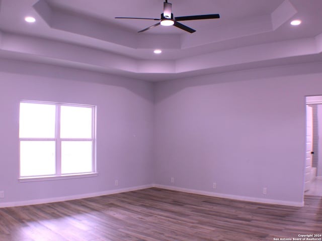 spare room featuring hardwood / wood-style floors, a raised ceiling, and ceiling fan