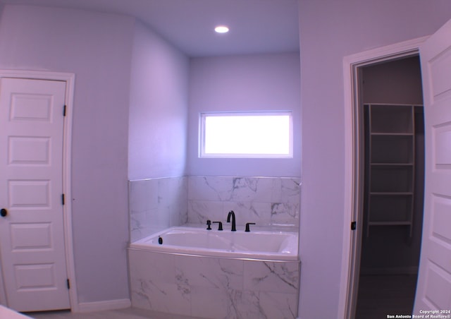 bathroom featuring a relaxing tiled tub