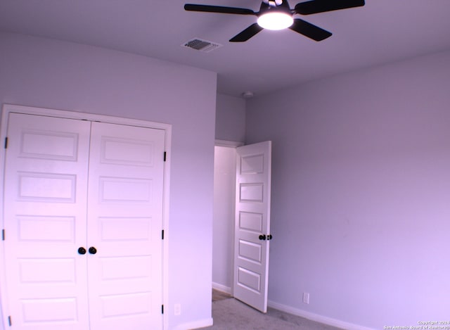 unfurnished bedroom with ceiling fan, a closet, and light colored carpet