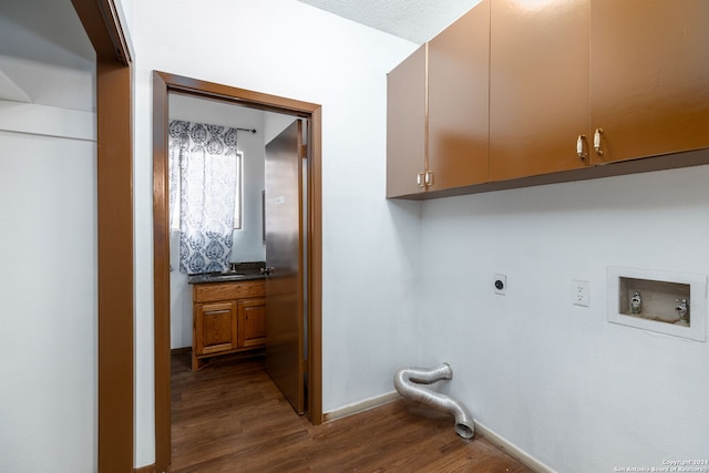 washroom with hookup for an electric dryer, dark wood-type flooring, hookup for a washing machine, and cabinets