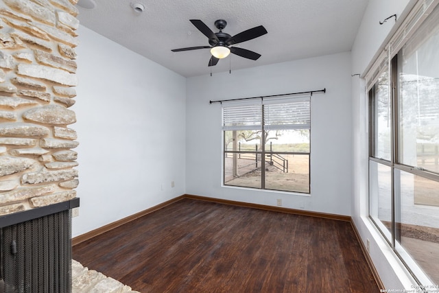 spare room with dark hardwood / wood-style flooring, a textured ceiling, and ceiling fan