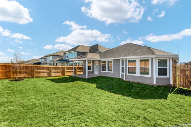 rear view of property featuring a lawn