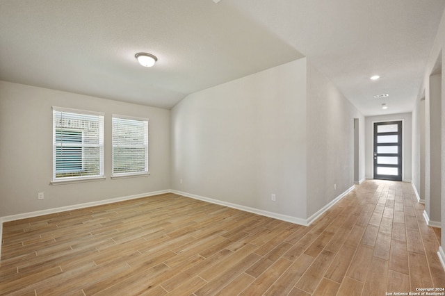 empty room featuring vaulted ceiling