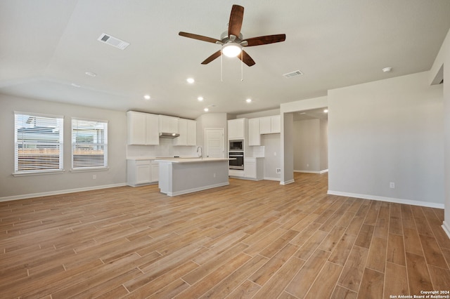 unfurnished living room featuring ceiling fan, light hardwood / wood-style floors, and sink