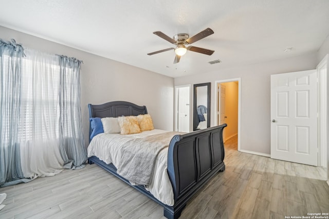 bedroom with light wood-type flooring, multiple windows, and ceiling fan