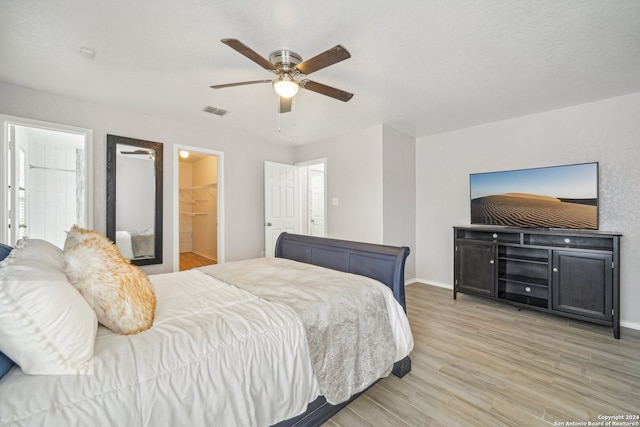 bedroom featuring hardwood / wood-style floors, ensuite bathroom, ceiling fan, a closet, and a spacious closet