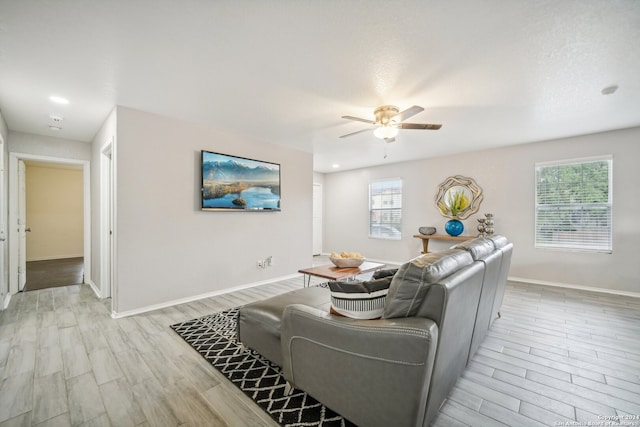 living room with light wood-type flooring and ceiling fan