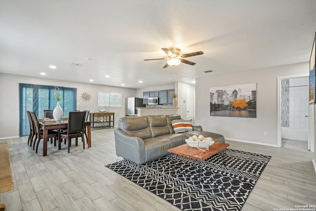 living room featuring ceiling fan and light hardwood / wood-style floors