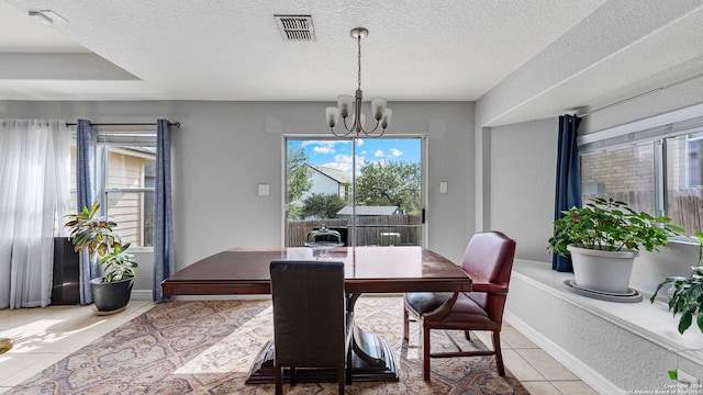 tiled dining space with a textured ceiling and a chandelier