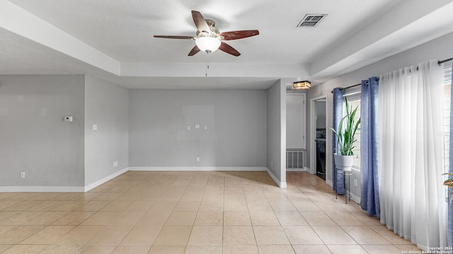 tiled spare room featuring a textured ceiling and ceiling fan