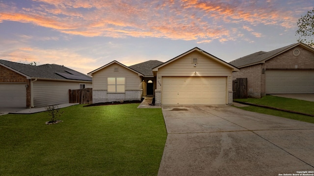 ranch-style home with a garage and a lawn