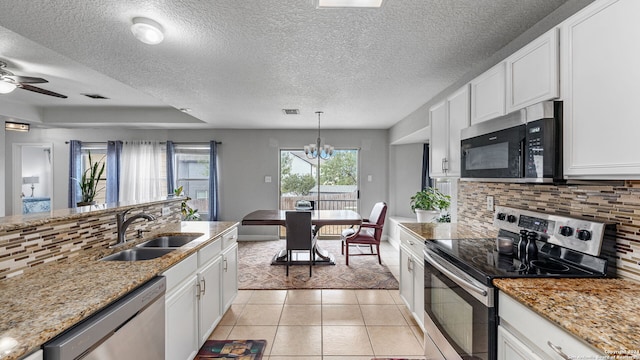 kitchen with light tile patterned flooring, white cabinetry, appliances with stainless steel finishes, backsplash, and sink