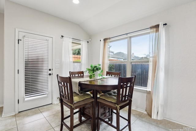 tiled dining space with vaulted ceiling