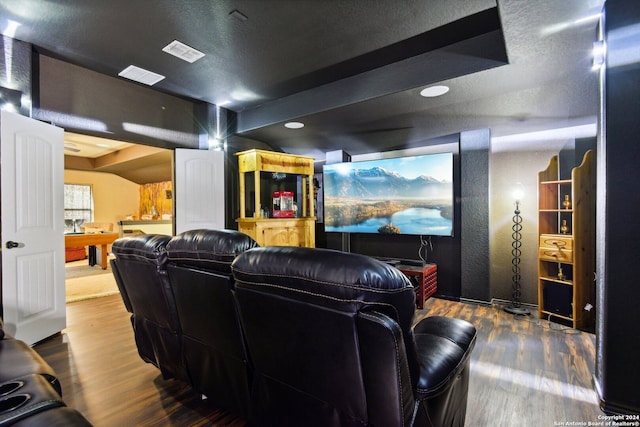 cinema room with hardwood / wood-style floors and a textured ceiling