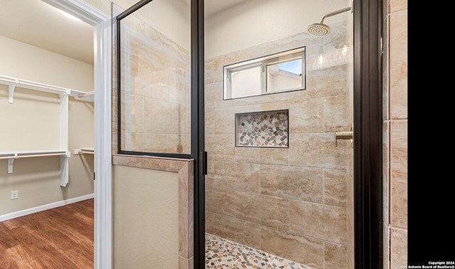 bathroom featuring wood-type flooring and a shower with shower door