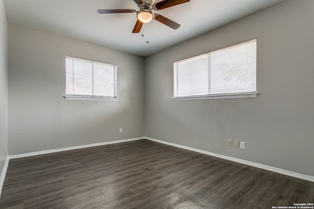 spare room featuring a wealth of natural light, dark hardwood / wood-style floors, and ceiling fan