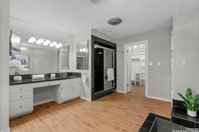 bathroom featuring vanity, wood-type flooring, and a shower with door