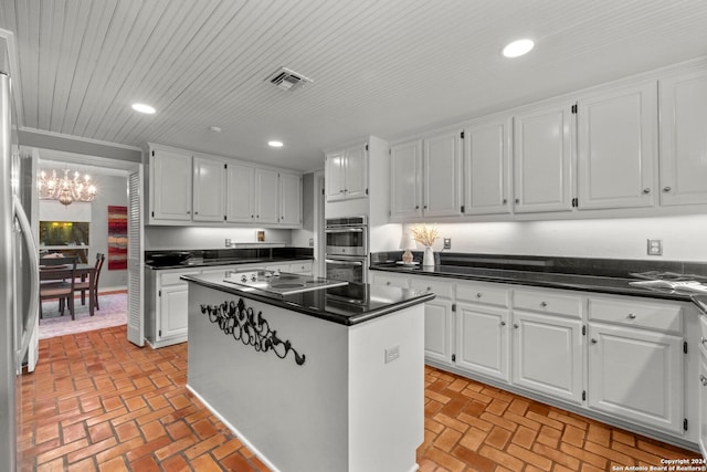 kitchen with white cabinetry, stainless steel appliances, a notable chandelier, and a kitchen island