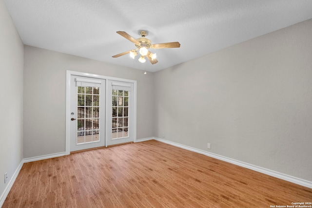 spare room with ceiling fan, a textured ceiling, and light hardwood / wood-style flooring