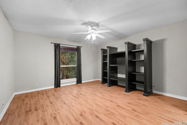 interior space featuring a textured ceiling, wood-type flooring, and ceiling fan