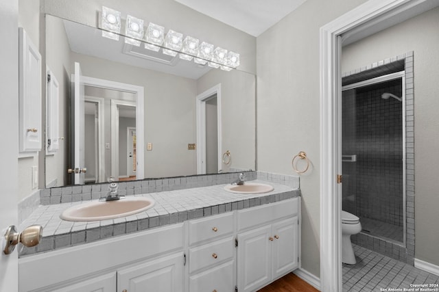 bathroom with tile patterned floors, vanity, toilet, and an enclosed shower