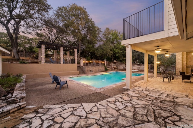 pool at dusk featuring a pergola and a patio