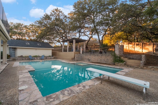 view of swimming pool with a diving board and a patio area