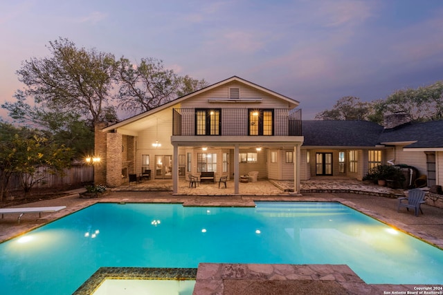 pool at dusk with a patio