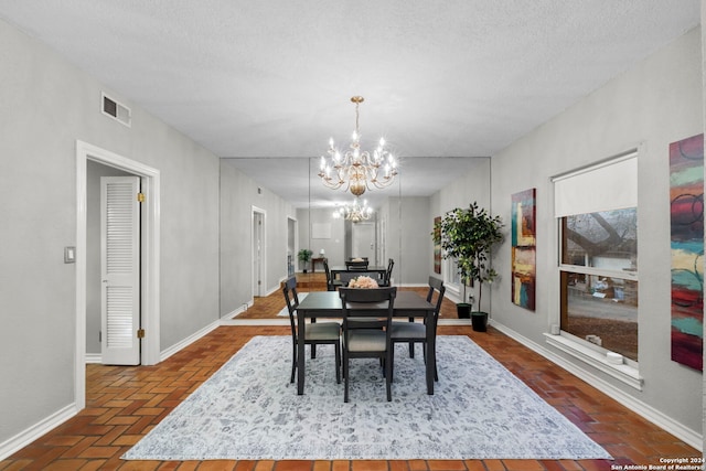 dining area with a chandelier and a textured ceiling