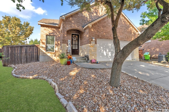 view of front of home featuring a garage, cooling unit, and a front yard