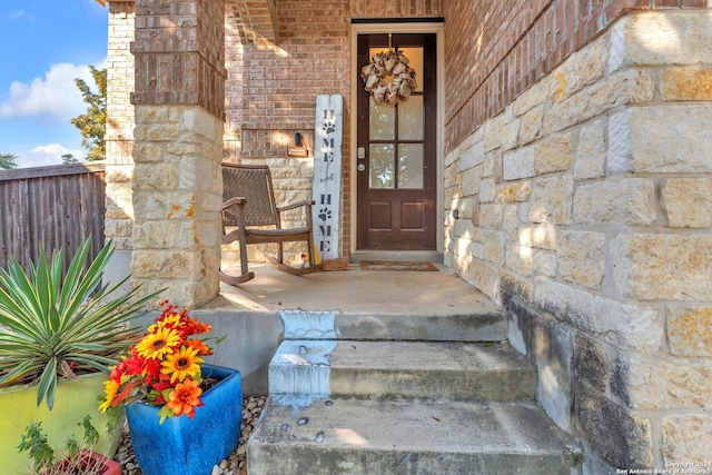12639 Perini Rnch, San Antonio, TX 78254 - doorway to property with stone siding, covered porch, and fence