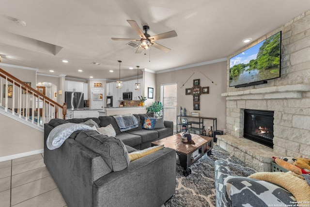12639 Perini Rnch, San Antonio, TX 78254 - living room featuring ornamental molding, stairway, a stone fireplace, a ceiling fan, and light tile patterned floors