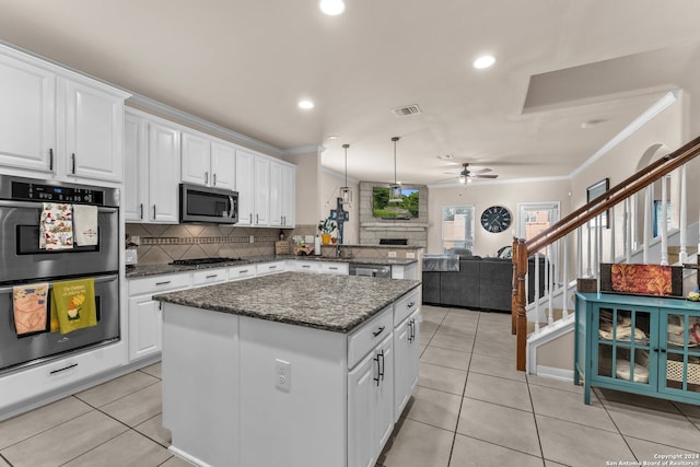 kitchen featuring a kitchen island, pendant lighting, appliances with stainless steel finishes, and white cabinets