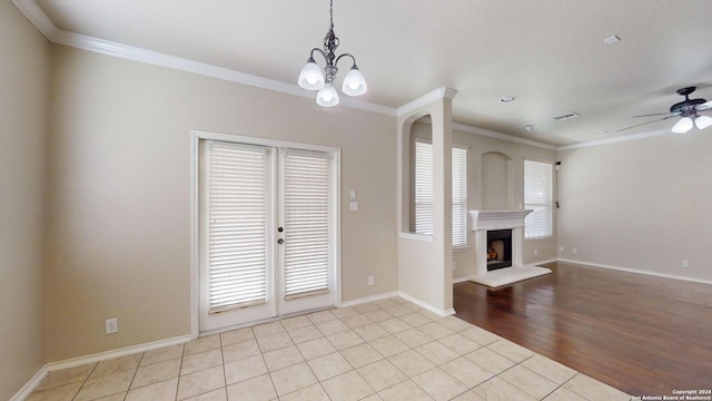 unfurnished living room featuring ornamental molding, light wood-type flooring, and ceiling fan with notable chandelier