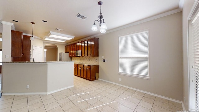 kitchen with light tile patterned flooring, a wealth of natural light, appliances with stainless steel finishes, and tasteful backsplash