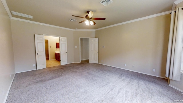 unfurnished bedroom with light colored carpet, ceiling fan, crown molding, and connected bathroom