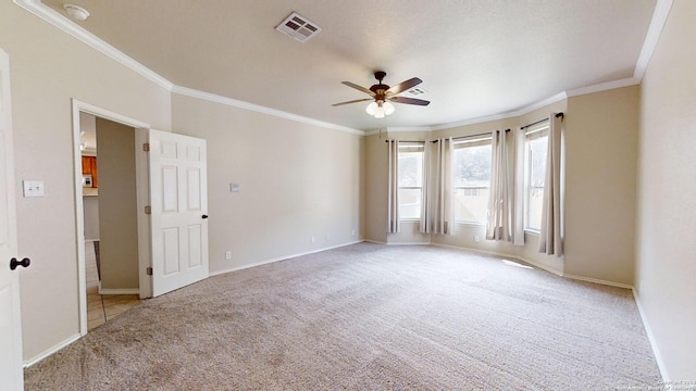 carpeted empty room with ceiling fan and crown molding