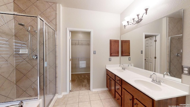 bathroom with an enclosed shower, vanity, and tile patterned floors