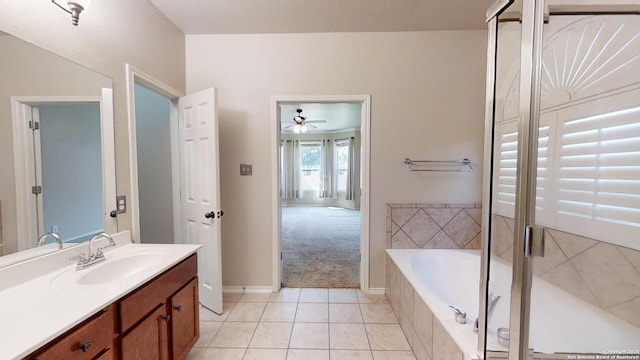 bathroom with a relaxing tiled tub, ceiling fan, tile patterned floors, and vanity